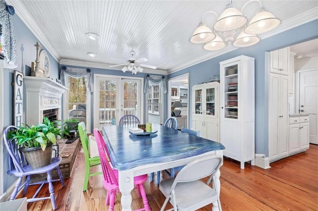 dining room with french doors, light hardwood / wood-style flooring, ceiling fan, and ornamental molding