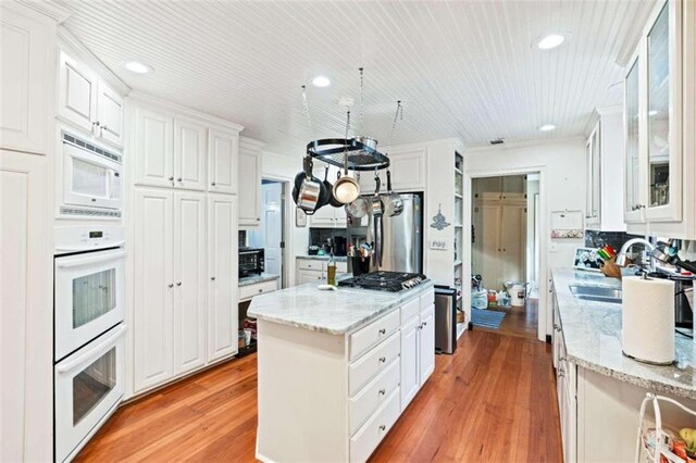 kitchen with white cabinets, light hardwood / wood-style floors, sink, and stainless steel appliances