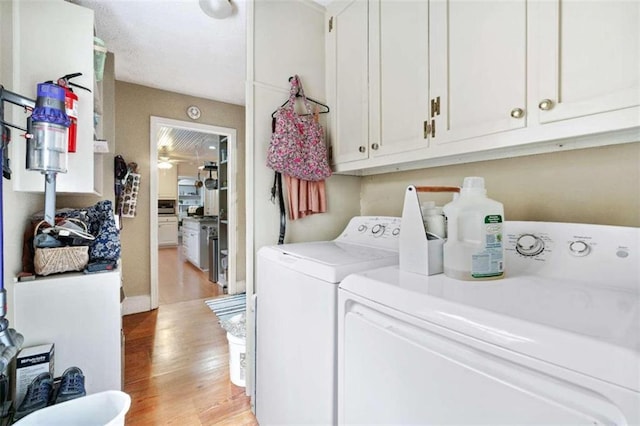 clothes washing area featuring washer and dryer, light hardwood / wood-style floors, cabinets, and ceiling fan