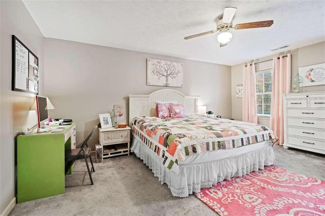 carpeted bedroom featuring a textured ceiling and ceiling fan