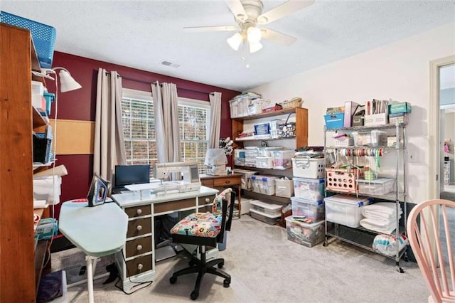 carpeted office with ceiling fan and a textured ceiling