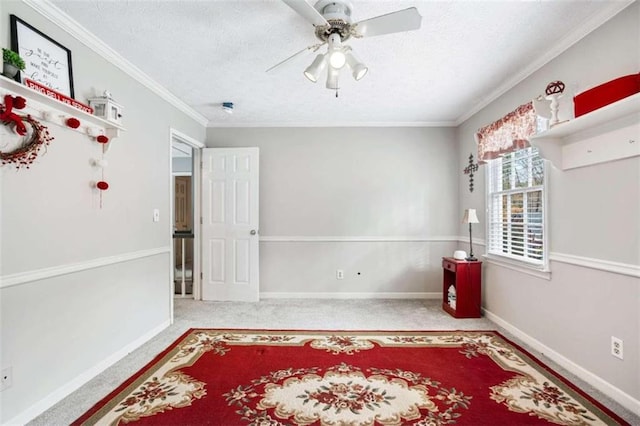 carpeted spare room featuring a textured ceiling, ceiling fan, and ornamental molding