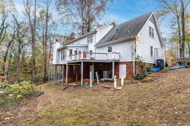 back of house featuring central AC unit and a wooden deck