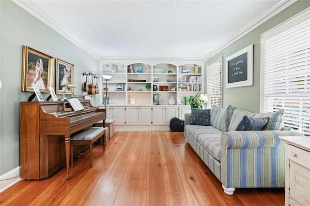 sitting room featuring crown molding, light hardwood / wood-style flooring, and a textured ceiling