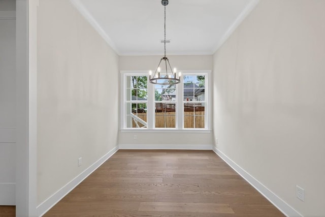 305 Milledge Ave, Monroe, GA 30655 - unfurnished dining area with a chandelier, crown molding, and wood finished floors