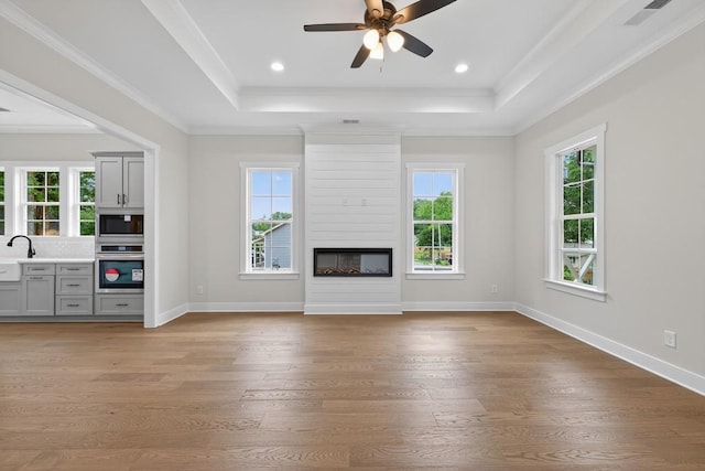305 Milledge Ave, Monroe, GA 30655 - unfurnished living room featuring a tray ceiling, wood finished floors, ceiling fan, a fireplace, and crown molding