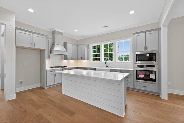 305 Milledge Ave, Monroe, GA 30655 - kitchen with appliances with stainless steel finishes, custom range hood, crown molding, decorative backsplash, and light countertops