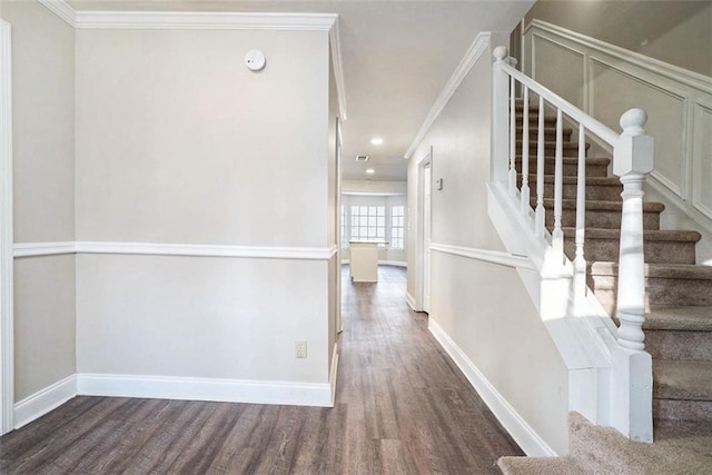 stairway with hardwood / wood-style floors and ornamental molding