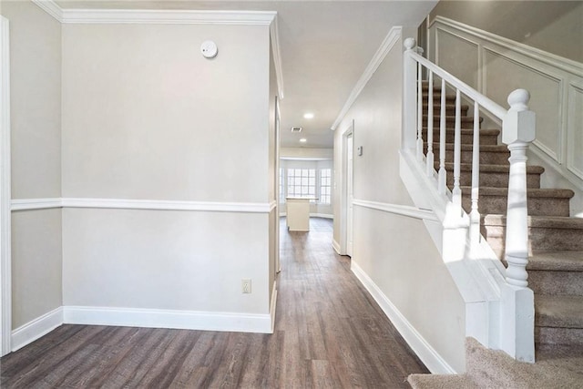 staircase with hardwood / wood-style flooring and ornamental molding