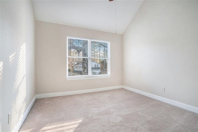 spare room with light carpet and lofted ceiling