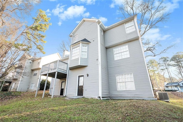 back of house featuring central AC unit, a yard, and a wooden deck