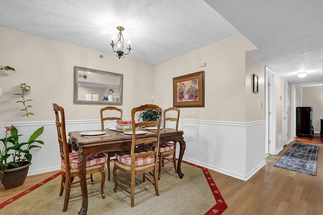 4081 Riverlook Pkwy SE Unit 13, Marietta, GA 30067 - dining area featuring wood finished floors, a textured ceiling, wainscoting, and a chandelier