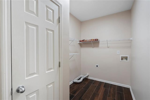 clothes washing area featuring electric dryer hookup, wood finish floors, washer hookup, baseboards, and laundry area