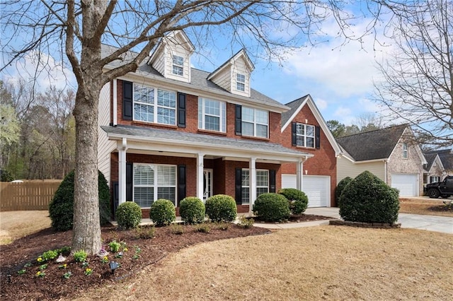 view of front facade featuring brick siding, concrete driveway, fence, and a garage