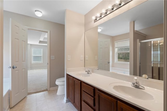 bathroom featuring a sink, a garden tub, and a healthy amount of sunlight