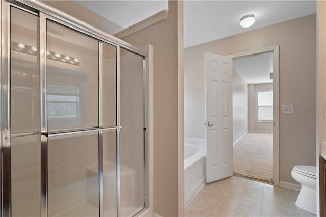 bathroom featuring a garden tub, toilet, baseboards, and a stall shower