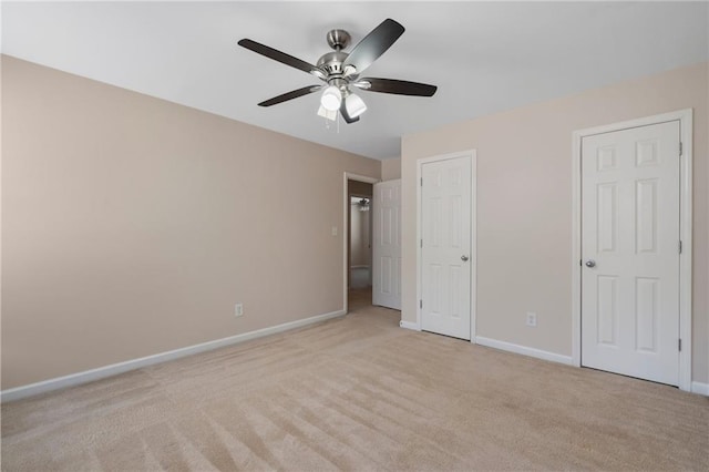 unfurnished bedroom with light colored carpet, baseboards, and ceiling fan