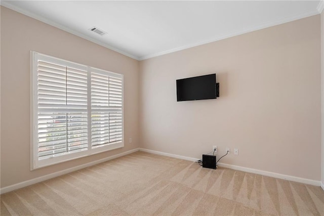 carpeted spare room featuring visible vents, baseboards, and crown molding