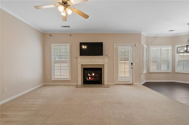 unfurnished living room featuring a fireplace with flush hearth, plenty of natural light, and crown molding