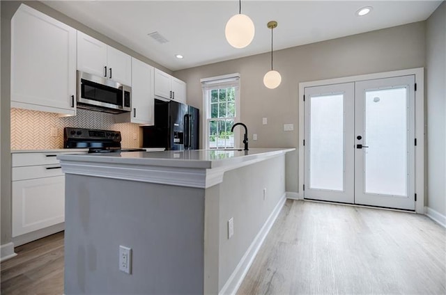 kitchen featuring white cabinetry, light wood-style floors, french doors, backsplash, and black appliances