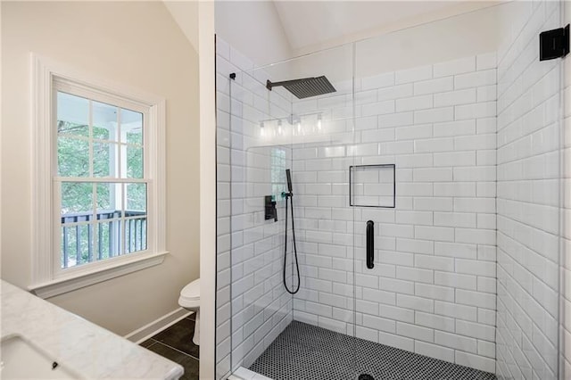 full bathroom featuring toilet, a stall shower, vaulted ceiling, vanity, and tile patterned flooring