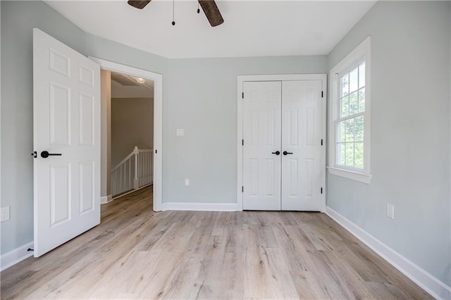 unfurnished bedroom with a ceiling fan, a closet, baseboards, and wood finished floors