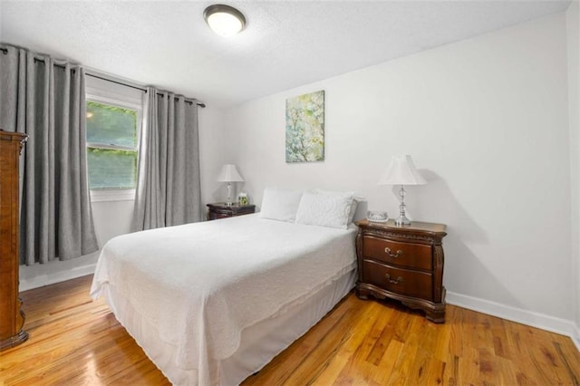 2021 Sherwood Dr SE, Marietta, GA 30062 - bedroom with light wood finished floors, baseboards, and a textured ceiling