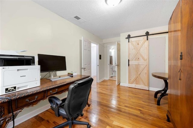 2021 Sherwood Dr SE, Marietta, GA 30062 - office area with a textured ceiling, light wood-style floors, baseboards, and a barn door