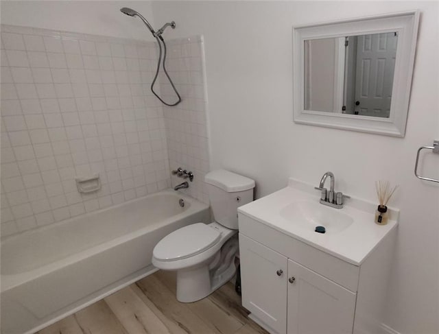 full bathroom with washtub / shower combination, vanity, wood finished floors, and toilet