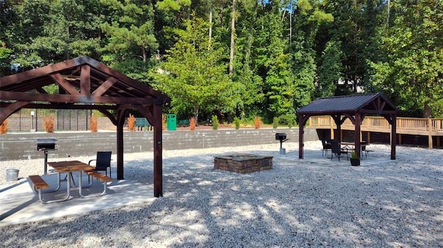 view of property's community featuring a gazebo, an outdoor fire pit, and a patio