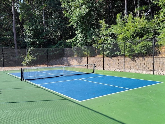 view of tennis court featuring fence