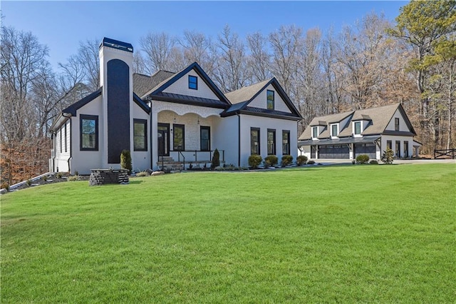 view of front facade featuring a garage, a front yard, and covered porch