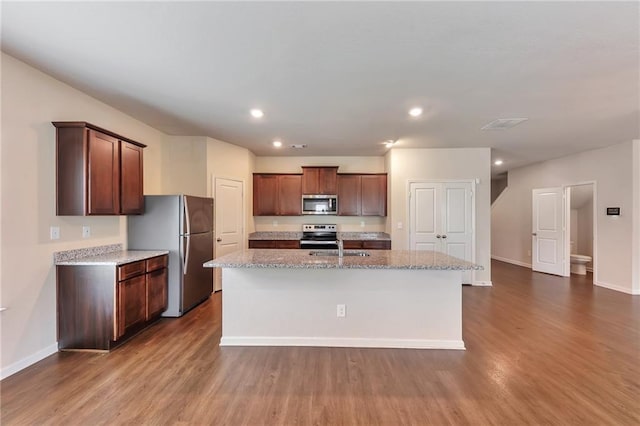 513 Moline Way, Locust Grove, GA 30248 - kitchen featuring stainless steel appliances, dark wood-type flooring, a center island with sink, light stone countertops, and recessed lighting