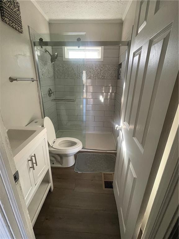 bathroom with crown molding, vanity, a shower with shower door, and toilet