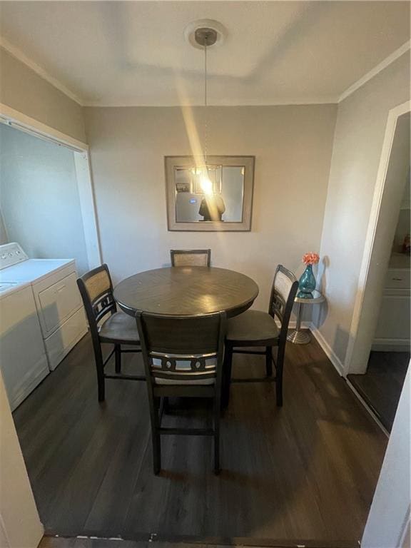 dining space with dark hardwood / wood-style floors, separate washer and dryer, and crown molding