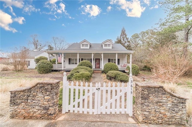 view of front facade with covered porch, a fenced front yard, and a gate