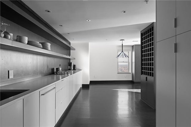 bar featuring hanging light fixtures and white cabinets