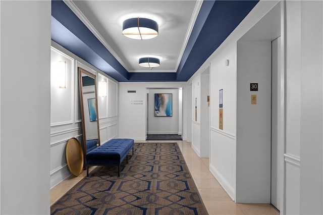 hall featuring crown molding, elevator, a raised ceiling, and light tile patterned floors