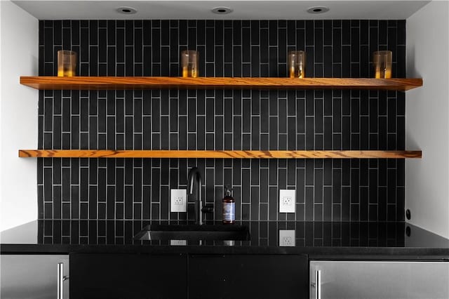 interior details with high end fridge, sink, and decorative backsplash