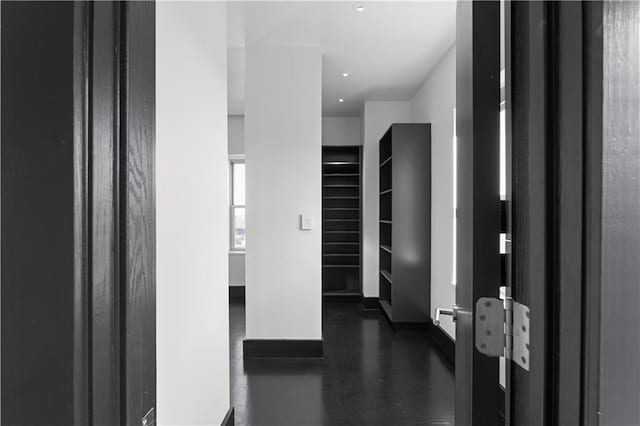 hallway with dark wood-type flooring and baseboard heating