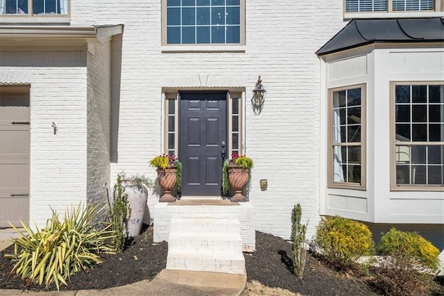 doorway to property featuring brick siding