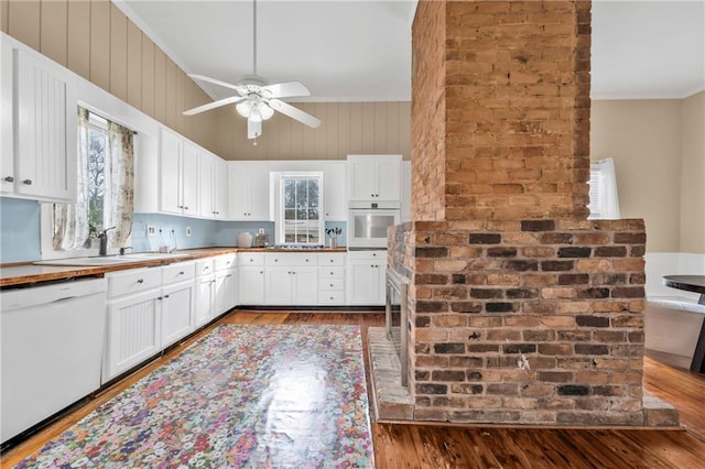 kitchen featuring white appliances, dark wood-style floors, white cabinets, and crown molding