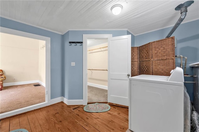 clothes washing area featuring hardwood / wood-style floors, laundry area, ornamental molding, and washer / dryer