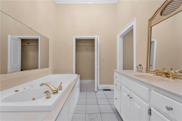 full bath featuring a tub with jets, a spacious closet, vanity, and tile patterned floors