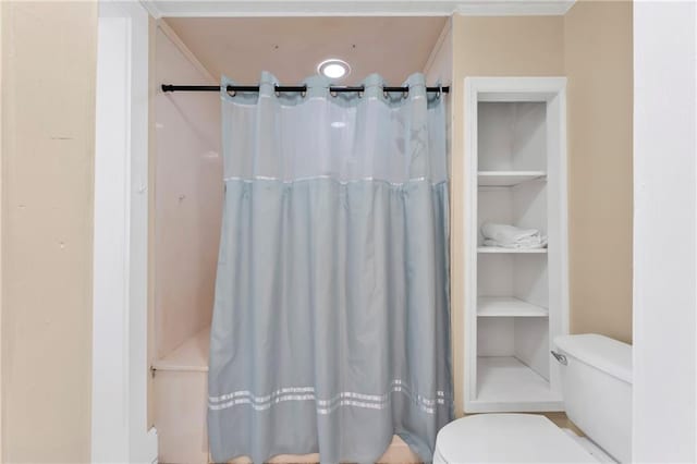 bathroom with built in shelves, curtained shower, ornamental molding, and toilet