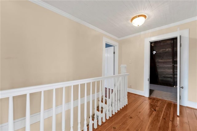 hall with baseboards, hardwood / wood-style floors, and crown molding