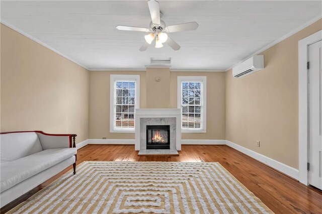 unfurnished living room featuring a premium fireplace, baseboards, an AC wall unit, wood-type flooring, and crown molding