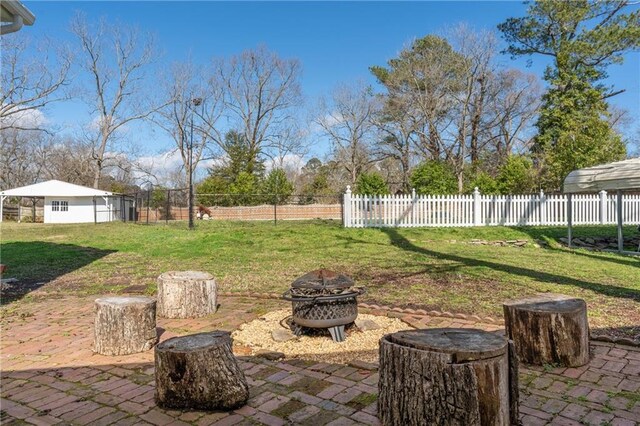 view of patio featuring an outdoor fire pit and fence