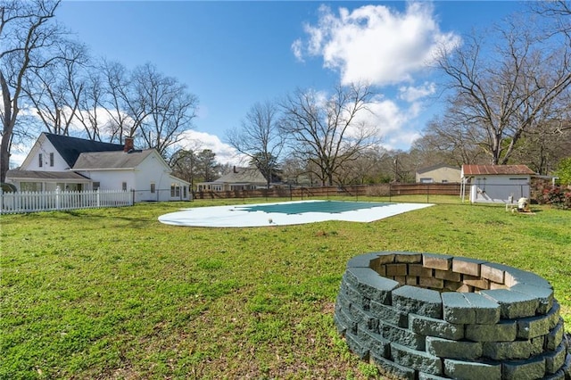 view of yard featuring a fenced backyard and a fire pit