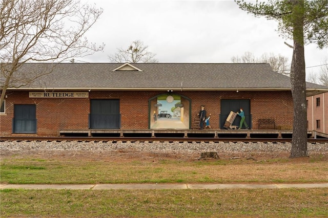 back of property with brick siding and a lawn